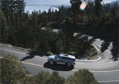A 2023 Lincoln Aviator® SUV is being driven on a winding mountain road | Seekins Lincoln in Fairbanks AK