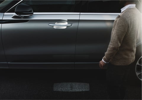 A person approaches a 2023 Lincoln Aviator® Grand Touring as the Lincoln Embrace sequence of welcome lighting illuminates | Seekins Lincoln in Fairbanks AK