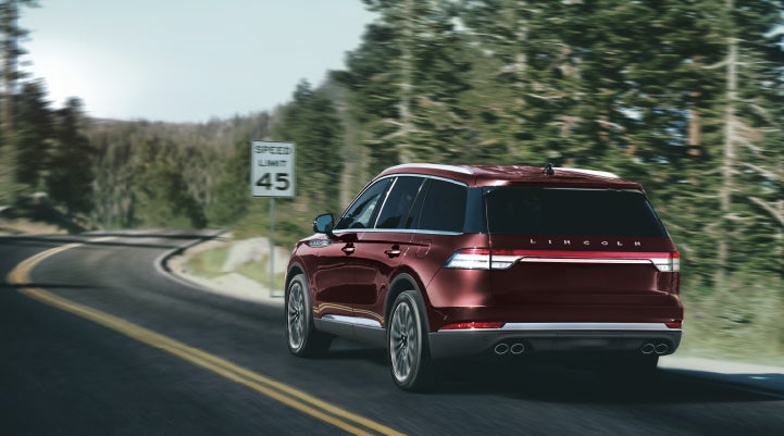 A 2024 Lincoln Aviator® SUV is being driven on a winding mountain road | Seekins Lincoln in Fairbanks AK