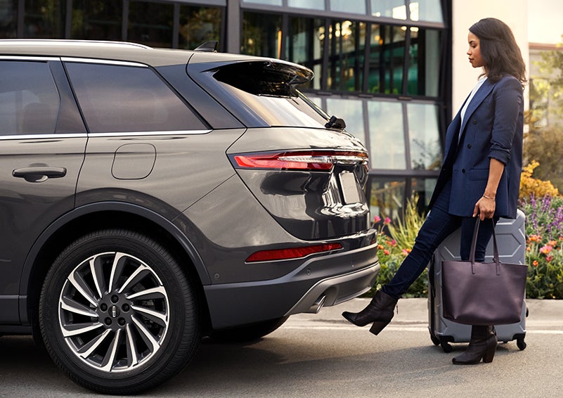 A woman with her hands full uses her foot to activate the available hands-free liftgate. | Seekins Lincoln in Fairbanks AK