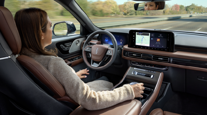 A woman is seen sitting in the driver’s seat of her 2025 Lincoln Aviator® SUV with her hands off the steering wheel. | Seekins Lincoln in Fairbanks AK