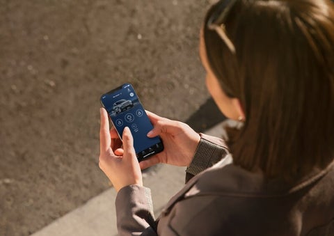 A person is shown interacting with a smartphone to connect to a Lincoln vehicle via the Lincoln Way® App. | Seekins Lincoln in Fairbanks AK