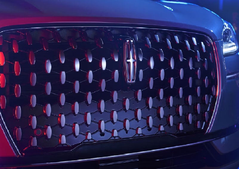 The grille of a 2025 Lincoln Corsair® SUV reflects neon light at night. | Seekins Lincoln in Fairbanks AK