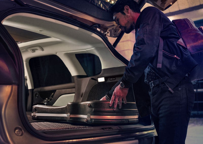 A man is shown loading cargo into the rear of a 2024 Lincoln Corsair® SUV with the second-row seats folded flat. | Seekins Lincoln in Fairbanks AK