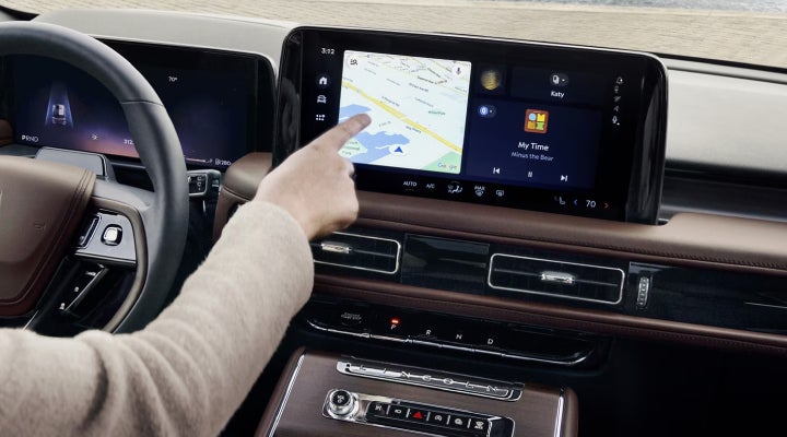 A person is tapping the center display touchscreen of a 2026 Lincoln Aviator® SUV. | Seekins Lincoln in Fairbanks AK