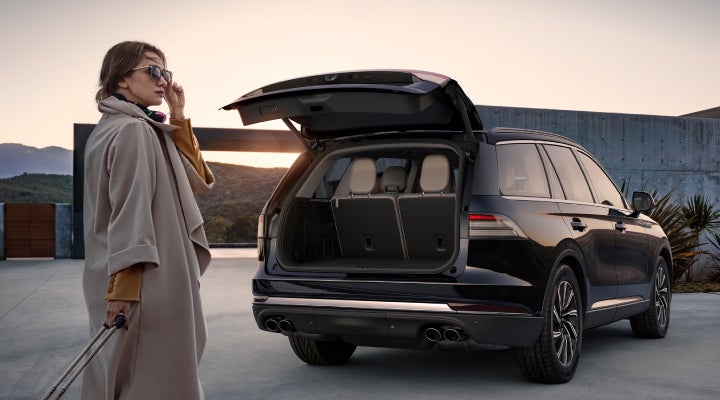 A woman approaches a 2026 Lincoln Aviator® SUV with its rear liftgate open. | Seekins Lincoln in Fairbanks AK