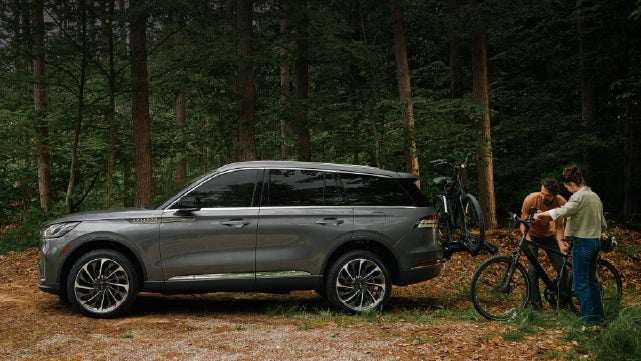 A father and son load e-bikes on a bike rack attached to a 2027 Lincoln Aviator® SUV. | Seekins Lincoln in Fairbanks AK